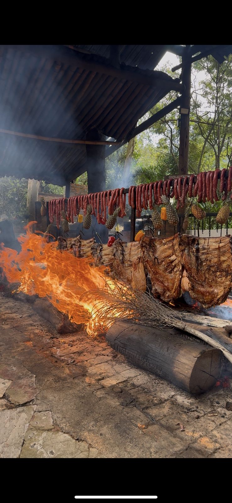 Costelas assando lentamente no fogo de chão
